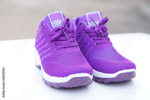Pair of new purple sneakers. Fashionable and comfortable sport footwears. outdoor background.  Concept, shoes for doing sport or exercise also can wear for traveling, hiking.      