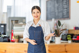 Opening a small business, AHappy Asian woman in an apron standing near a bar counter coffee shop, Small business owner, restaurant, barista, cafe, Online, SME, entrepreneur, and seller concept
