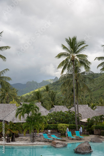 Blue tropical pool surrounded by palm trees and mountains