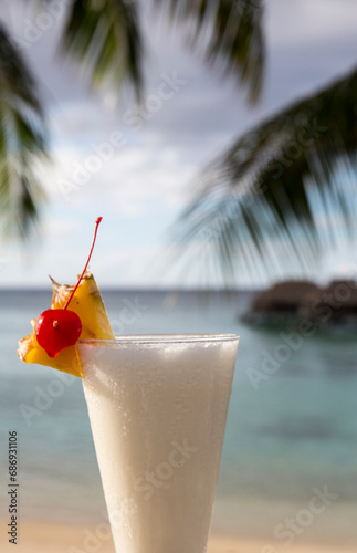 Cocktail on the beach in Tahiti over the ocean with pineapples and cherry and a pina collada 