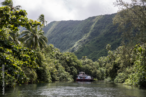 An old fashioned boat in a lush green tropical paradise in Tahiti 