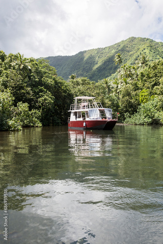 An old fashioned boat in a lush green tropical paradise in Tahiti 