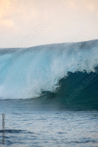 Blue and golden waves on the ocean at sunset in Tahiti ready for surfer