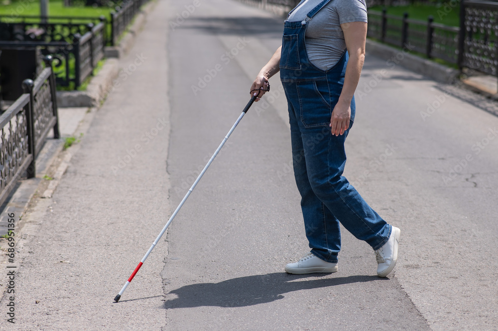 Blind pregnant woman crosses the street with the help of a tactile cane. Blind pregnant woman crosses the street with the help of a tactile cane.