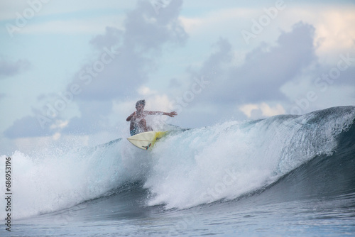 Surfing waves in Tahiti at sunset
