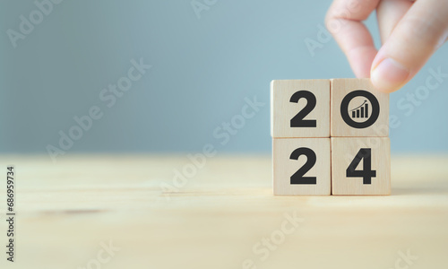 Business growth concept in 2024. Business goals and achievement. Sustainable development. Wooden cubes inscripted 2024 and growth icon on smart background. Positive indicators banner.