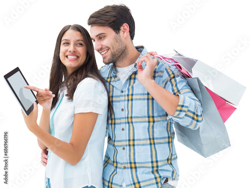 Digital png photo of happy diverse couple with shopping bags using tablet on transparent background