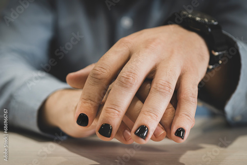 Man with painted nails. Design of male nails. men manicure. The nails are painted in a fashionable black color photo