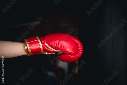 Hand of boxing gloves punching bag over black background. Doing boxing training at the gym. Challenge and training workout sport concept. © Bordinthorn