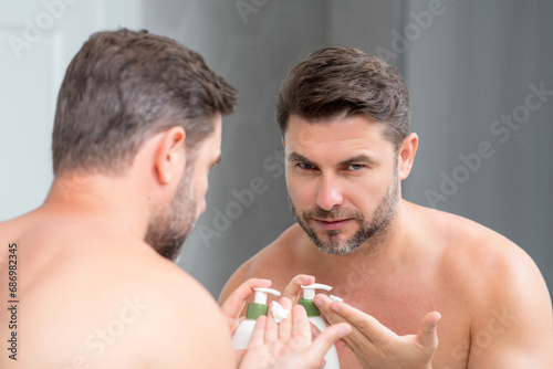 Sexy bearded man care of skin. Unshaven man with bristle and perfect skin. Male beauty and skincare concept. Man cosmetic, skin treatment. Morning hygiene. Mens cosmetics and spa and wellness.