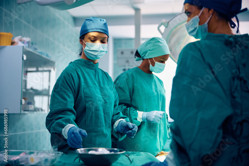Group of female doctors performing surgical procedure in operating room. photo