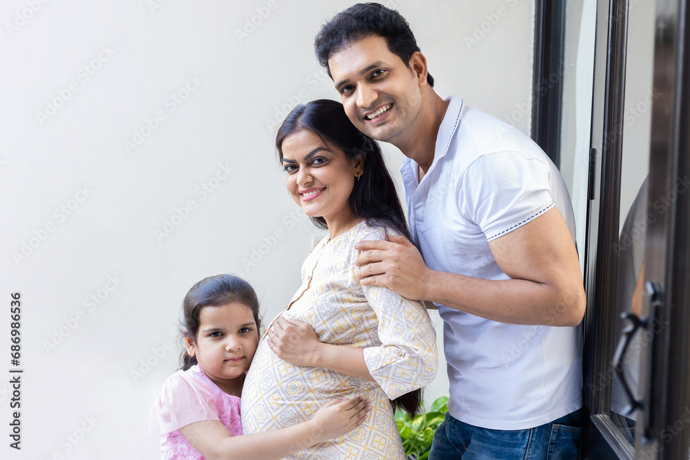 Portrait of happy indian pregnant woman with her husband and daughter at home, Awaiting for baby. Portrait of happy indian pregnant woman with her husband and daughter at home, Awaiting for baby.
