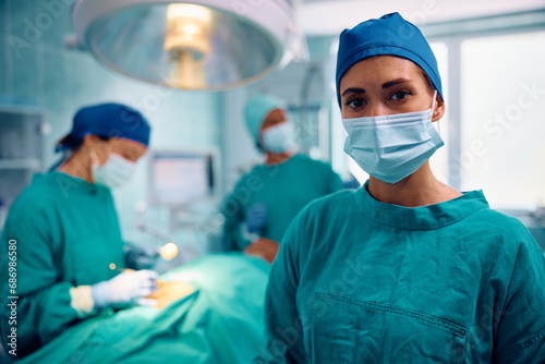 Young surgical nurse in operating room looking at camera.