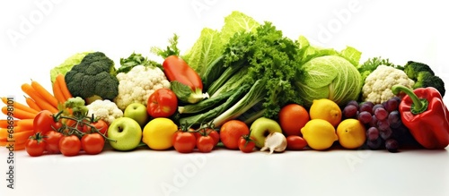 On a white isolated background  a colorful assortment of vegetables and fruits     green lettuce  orange carrots  red tomatoes     are arranged in a salad  ready to be enjoyed as a healthy and