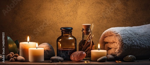 Spa treatment relaxation with massage therapy by candlelight, utilizing beauty care products such as massage stones, essential oils, and a towel on the table with candles and oils. photo