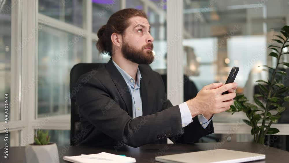 Surprised man employee trying to catching internet connection on modern smartphone at personal work desk. Hardworking male manager requiring stable network to performing work duties indoors. Surprised man employee trying to catching internet connection on modern smartphone at personal work desk. Hardworking male manager requiring stable network to performing work duties indoors.