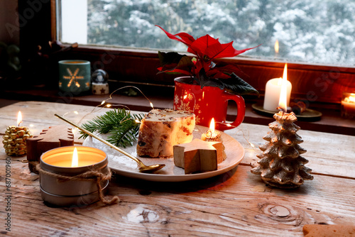 On a rustic table: poinsettia, candles, panettone for Christmas