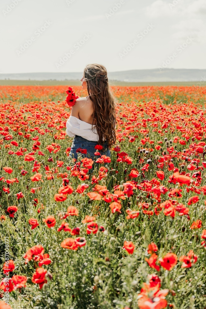 Woman poppies field. Back view of a happy woman with long hair in a poppy field and enjoying the beauty of nature in a warm summer day. Woman poppies field. Back view of a happy woman with long hair in a poppy field and enjoying the beauty of nature in a warm summer day.