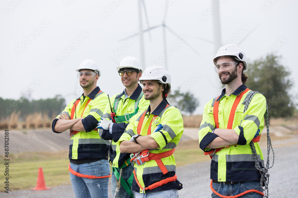 Group of male engineer working at wind turbines farm, planing maintenance of wind turbines at windmill field farm Group of male engineer working at wind turbines farm, planing maintenance of wind turbines at windmill field farm