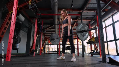 girl trains glutes and lower back in the gym. barbell deadlifts  photo