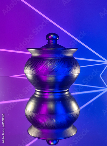A clay cooking pot with pink and blue lighting