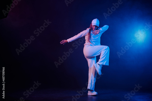 a girl in light clothes dances on a neon background in smoke, modern dance