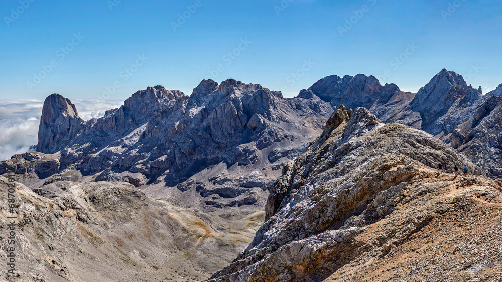 Mountain landscape in Fuentede, Naranjo de Bulnes on the left and hikers on the right. Picos de Europa National Park, Spain. High quality 4k images