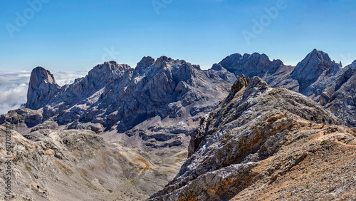 Mountain landscape in Fuentede, Naranjo de Bulnes on the left and hikers on the right. Picos de Europa National Park, Spain. High quality 4k images