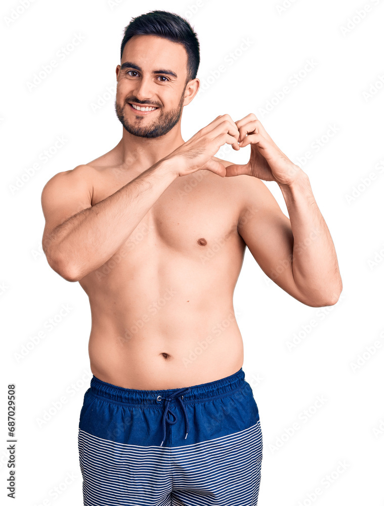 Young handsome man wearing swimwear smiling in love showing heart symbol and shape with hands. romantic concept. Young handsome man wearing swimwear smiling in love showing heart symbol and shape with hands. romantic concept.