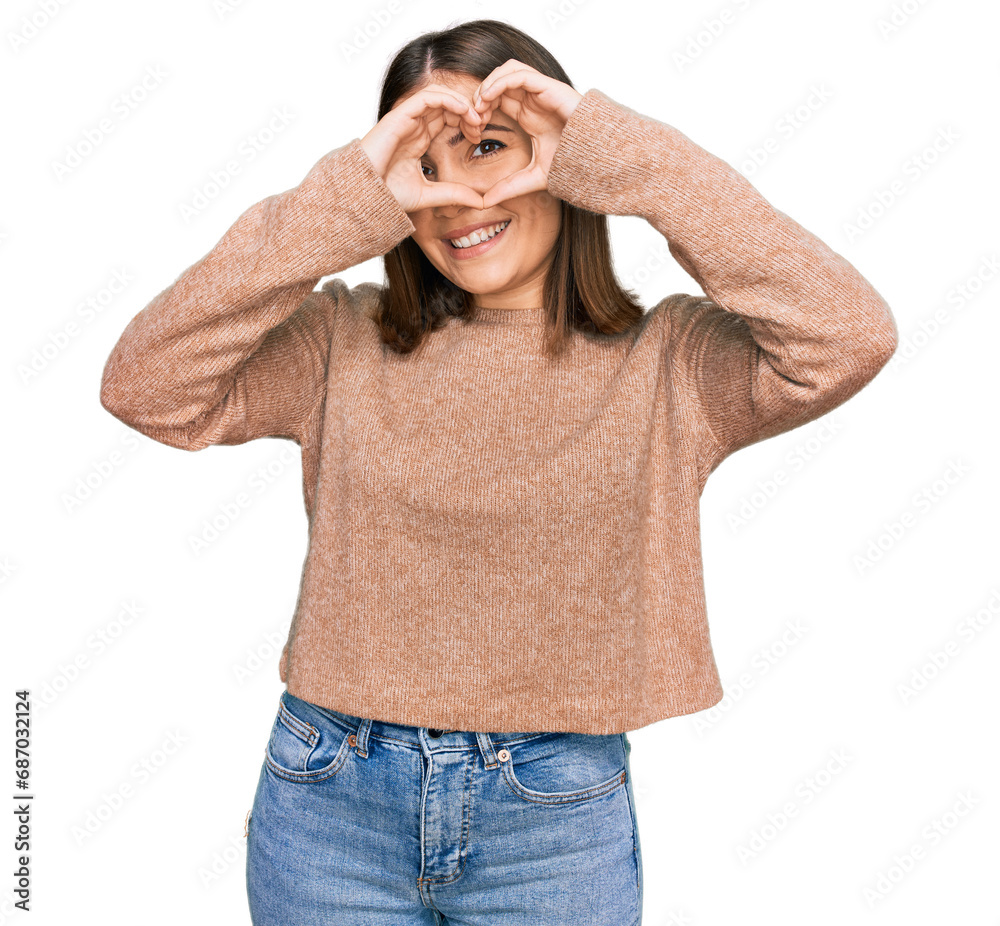 Young beautiful woman wearing casual clothes doing heart shape with hand and fingers smiling looking through sign Young beautiful woman wearing casual clothes doing heart shape with hand and fingers smiling looking through sign