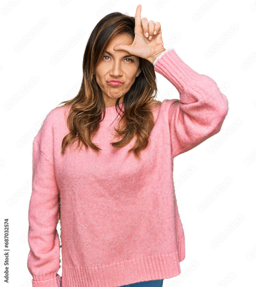 Young hispanic woman wearing casual clothes making fun of people with fingers on forehead doing loser gesture mocking and insulting. Young hispanic woman wearing casual clothes making fun of people with fingers on forehead doing loser gesture mocking and insulting.