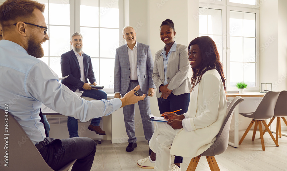 Group of business people chatting on a meeting. Company employees talking in the office and making great decisions with brainstorming. Cowokers listen to their colleague sitting in a circle. Group of business people chatting on a meeting. Company employees talking in the office and making great decisions with brainstorming. Cowokers listen to their colleague sitting in a circle.