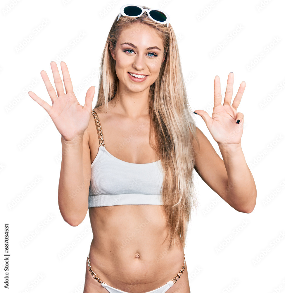 Beautiful young blonde woman wearing bikini showing and pointing up with fingers number nine while smiling confident and happy. Beautiful young blonde woman wearing bikini showing and pointing up with fingers number nine while smiling confident and happy.
