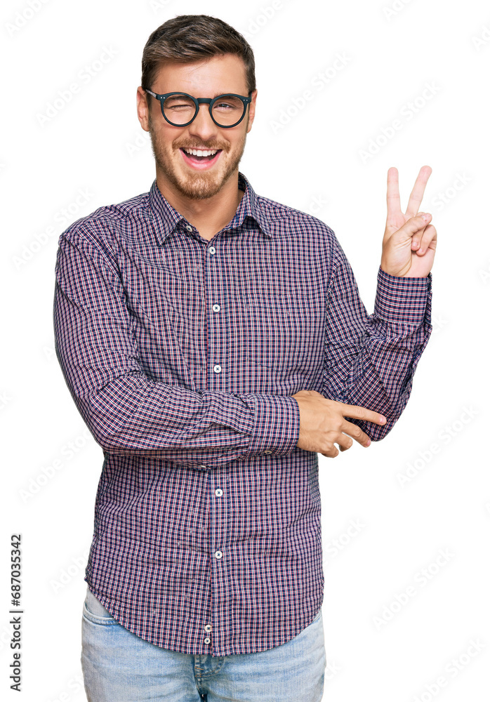 Handsome caucasian man wearing casual clothes and glasses smiling with happy face winking at the camera doing victory sign. number two. Handsome caucasian man wearing casual clothes and glasses smiling with happy face winking at the camera doing victory sign. number two.