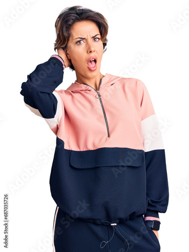 Young beautiful woman wearing sportswear in shock face, looking skeptical and sarcastic, surprised with open mouth © Krakenimages.com