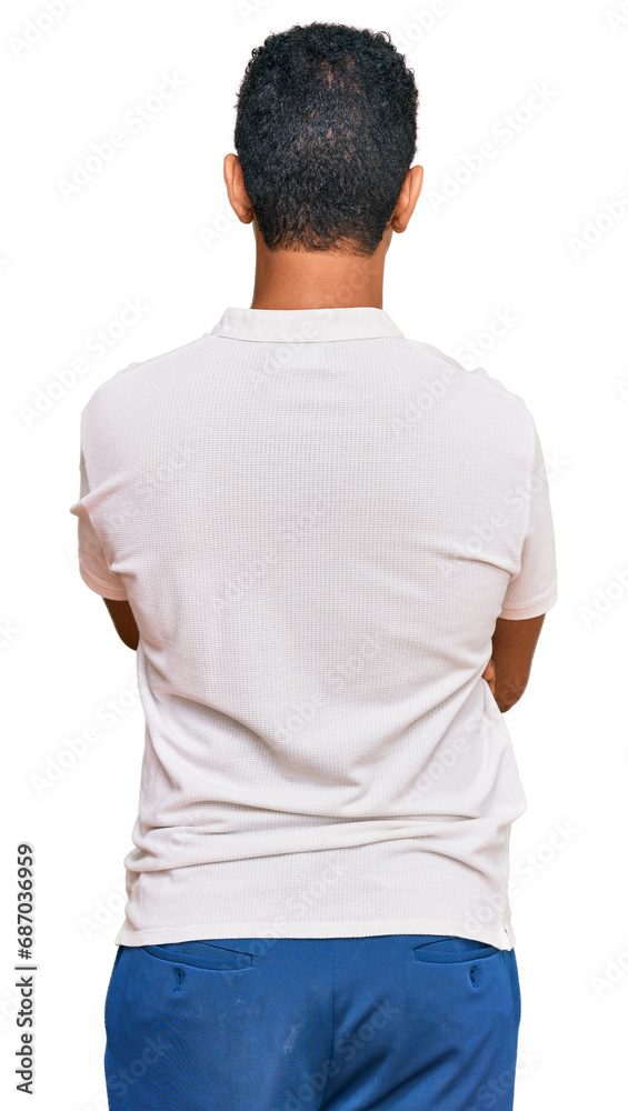 Young arab man wearing casual clothes standing backwards looking away with crossed arms Young arab man wearing casual clothes standing backwards looking away with crossed arms