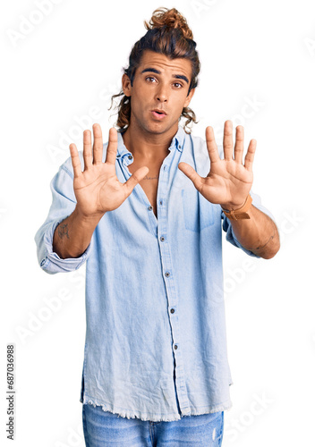 Young hispanic man wearing summer style moving away hands palms showing refusal and denial with afraid and disgusting expression. stop and forbidden. © Krakenimages.com