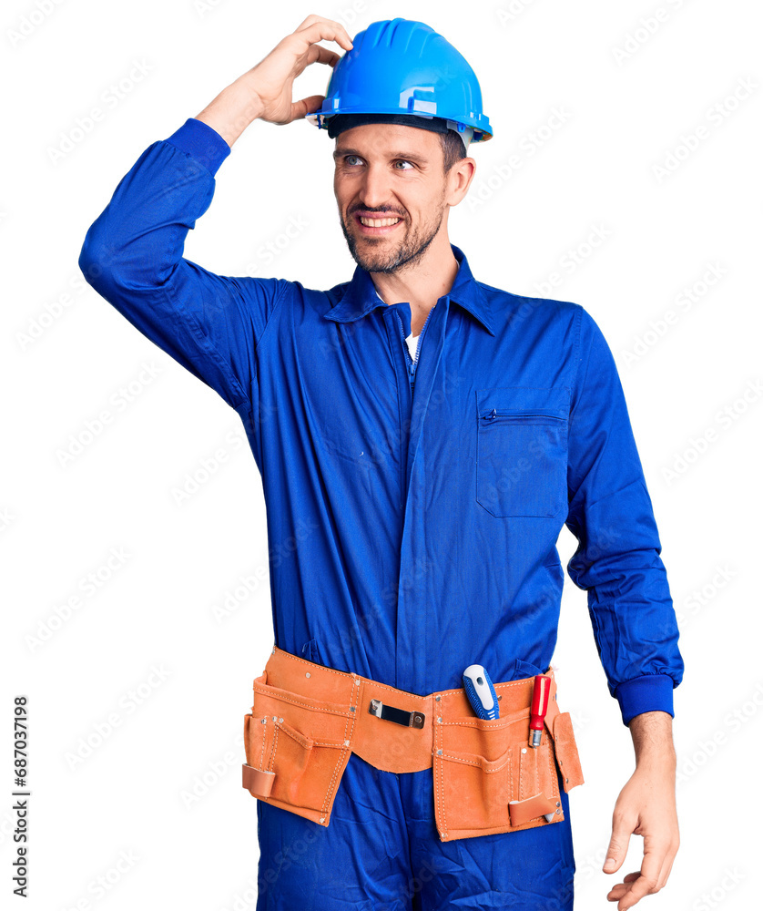 Young handsome man wearing worker uniform and hardhat smiling confident touching hair with hand up gesture, posing attractive and fashionable Young handsome man wearing worker uniform and hardhat smiling confident touching hair with hand up gesture, posing attractive and fashionable