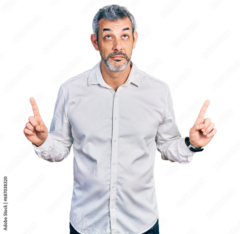 Middle age hispanic with grey hair wearing casual white shirt pointing up looking sad and upset, indicating direction with fingers, unhappy and depressed. Middle age hispanic with grey hair wearing casual white shirt pointing up looking sad and upset, indicating direction with fingers, unhappy and depressed.
