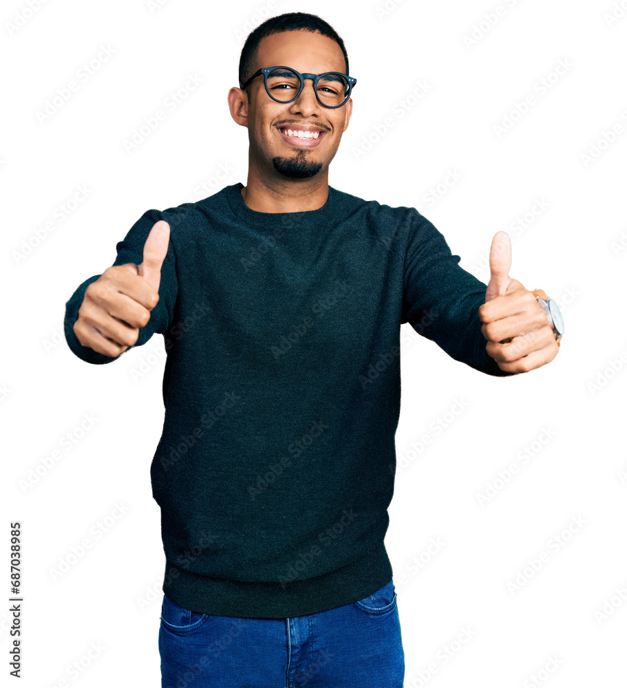 Naklejka premium Young african american man wearing casual clothes and glasses approving doing positive gesture with hand, thumbs up smiling and happy for success. winner gesture.