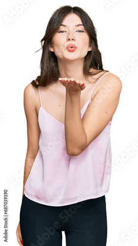 Young beautiful caucasian girl wearing casual clothes looking at the camera blowing a kiss with hand on air being lovely and sexy. love expression.