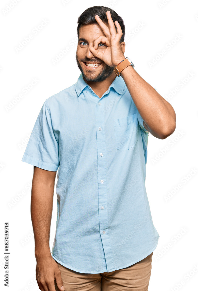 Fototapeta premium Handsome hispanic man wearing casual clothes doing ok gesture with hand smiling, eye looking through fingers with happy face.