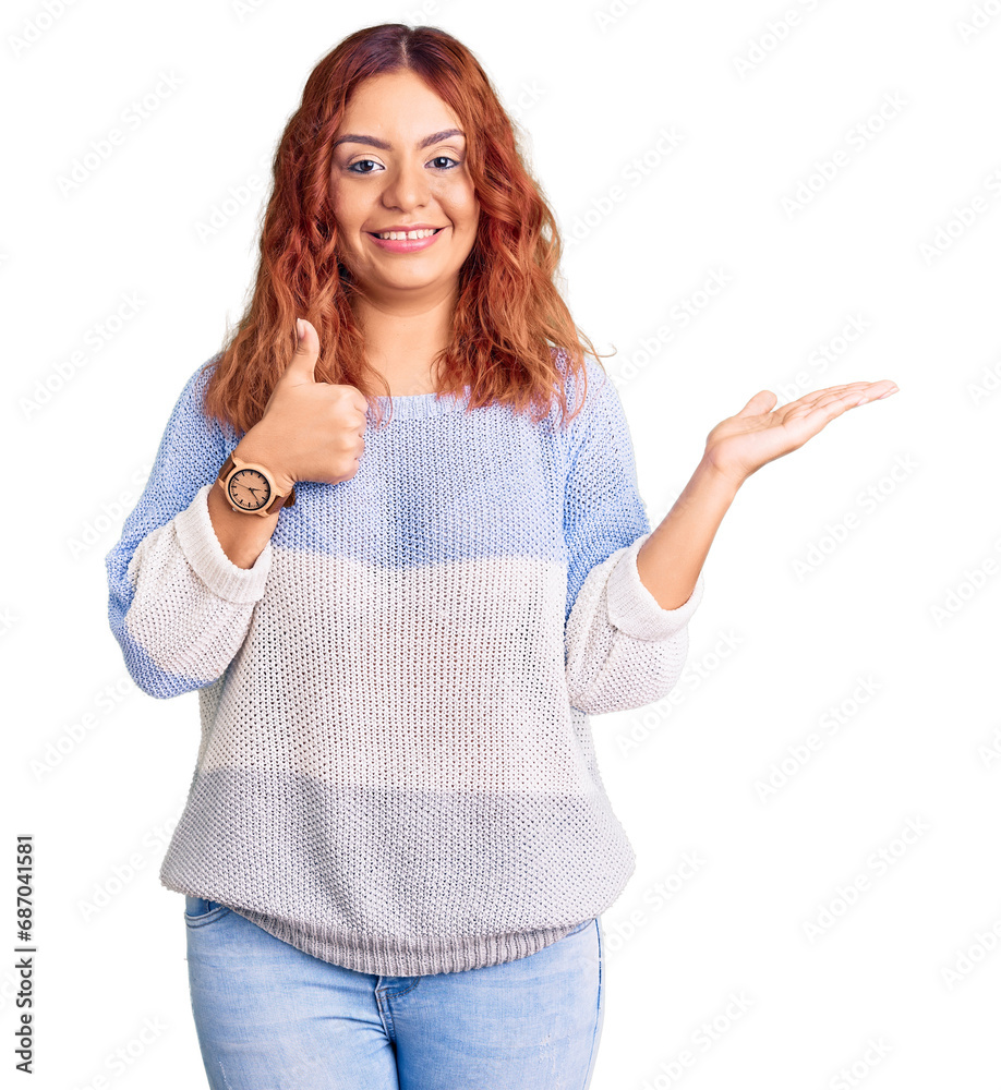 Young latin woman wearing casual clothes showing palm hand and doing ok gesture with thumbs up, smiling happy and cheerful Young latin woman wearing casual clothes showing palm hand and doing ok gesture with thumbs up, smiling happy and cheerful