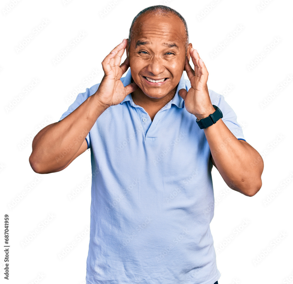 Fototapeta premium Hispanic middle age man wearing casual t shirt covering ears with fingers with annoyed expression for the noise of loud music. deaf concept.