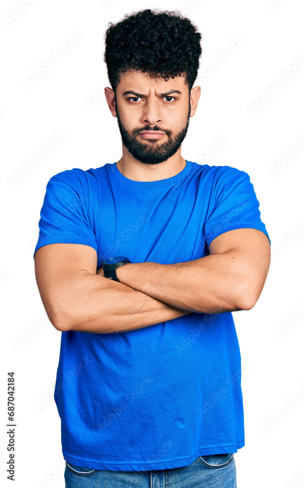Young arab man with beard wearing casual blue t shirt skeptic and nervous, disapproving expression on face with crossed arms. negative person. Young arab man with beard wearing casual blue t shirt skeptic and nervous, disapproving expression on face with crossed arms. negative person.