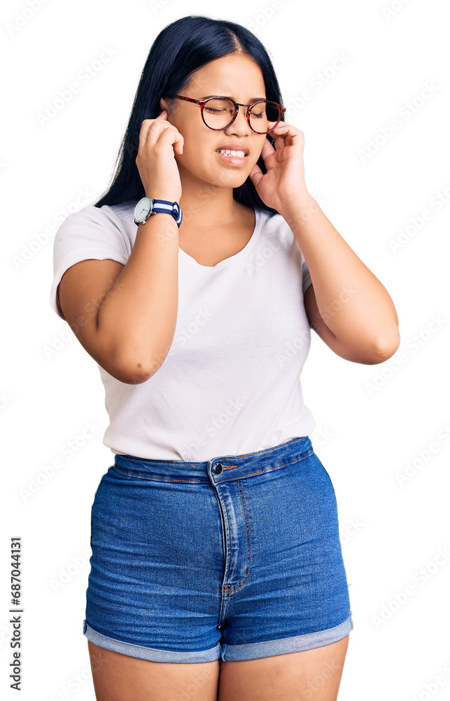 Young beautiful asian girl wearing casual clothes and glasses covering ears with fingers with annoyed expression for the noise of loud music. deaf concept. Young beautiful asian girl wearing casual clothes and glasses covering ears with fingers with annoyed expression for the noise of loud music. deaf concept.