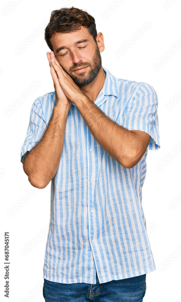 Handsome young man with beard wearing casual fresh shirt sleeping tired dreaming and posing with hands together while smiling with closed eyes. Handsome young man with beard wearing casual fresh shirt sleeping tired dreaming and posing with hands together while smiling with closed eyes.