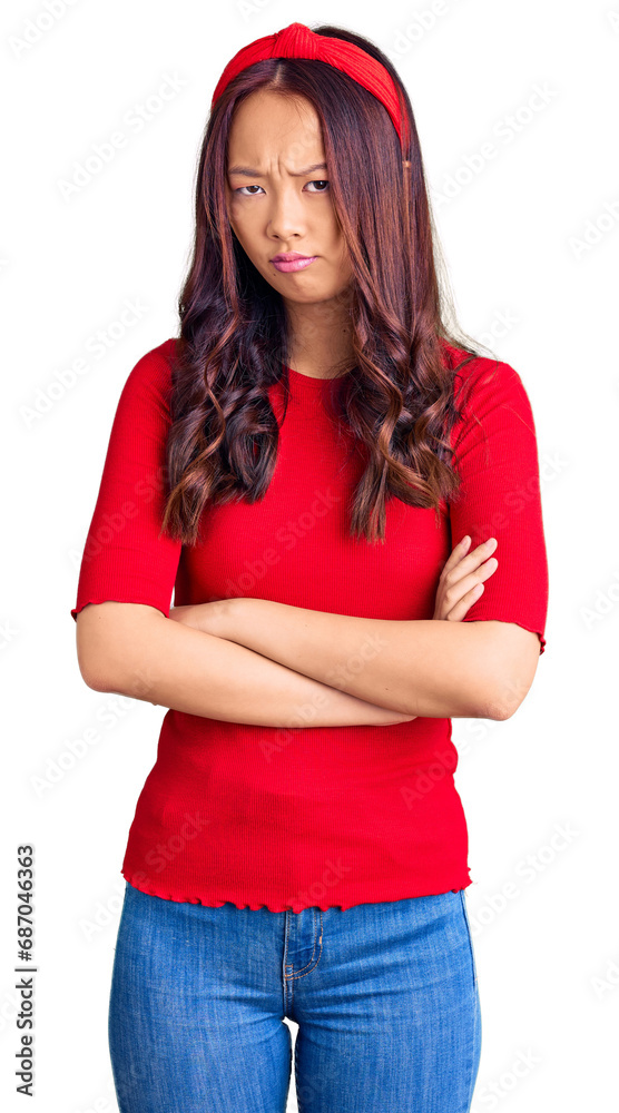 Young beautiful chinese girl wearing casual clothes and diadem skeptic and nervous, disapproving expression on face with crossed arms. negative person. Young beautiful chinese girl wearing casual clothes and diadem skeptic and nervous, disapproving expression on face with crossed arms. negative person.