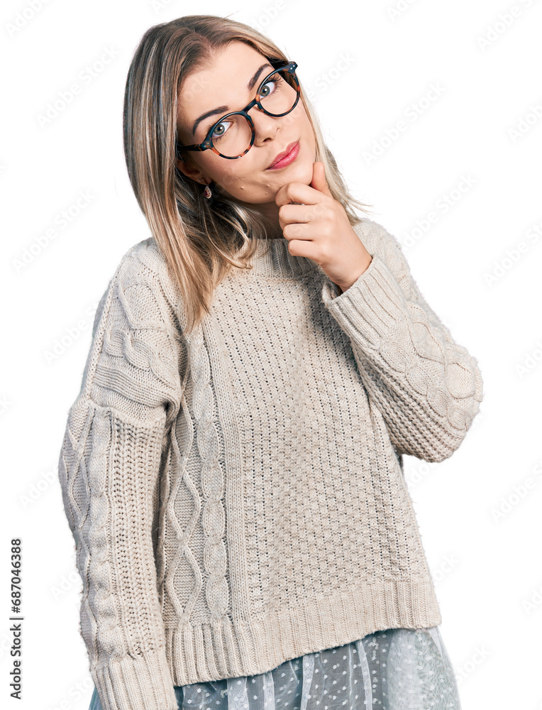 Young blonde woman wearing glasses thinking worried about a question, concerned and nervous with hand on chin Young blonde woman wearing glasses thinking worried about a question, concerned and nervous with hand on chin