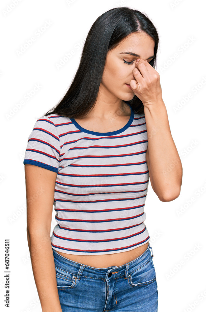 Young hispanic girl wearing casual striped t shirt tired rubbing nose and eyes feeling fatigue and headache. stress and frustration concept. Young hispanic girl wearing casual striped t shirt tired rubbing nose and eyes feeling fatigue and headache. stress and frustration concept.
